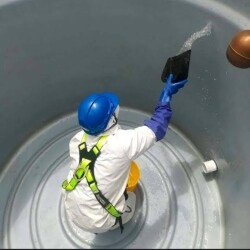 Professional cleaning inside water tank with safety equipment